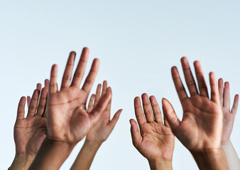 Raise your hands in support of each other. Shot of a group of hands reaching up against a white...