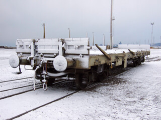 An isolated empty freight wagon covered with snow