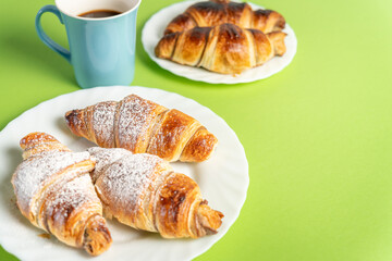 Sweet moment: croissants and coffee with chocolate. Close up of delicious chocolate croissants sprinkled with fine sugar. High quality photo