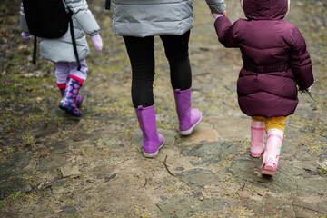 Legs of mother and daughters in rubber boots. Close up gumboots.