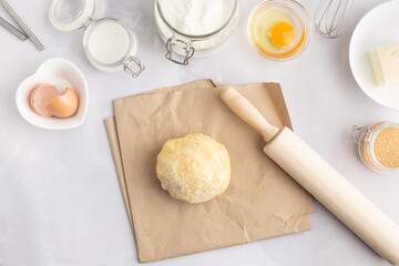Various baking ingredients - flour, eggs, sugar, butter and kitchen utensils on grey background. Top view.
