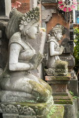 Fototapeta na wymiar Stone statue with hands in a praying atthe temple' entrance on Bali, Indonesia.