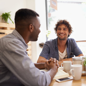 Dude, So How Are You Doing. Two Young Men Having A Conversation While Having Coffee At A Cafe.