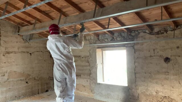 Male Worker In PPE Suit Scrap Wood Beam With Axe To Get Rid of the Worm-eaten parts