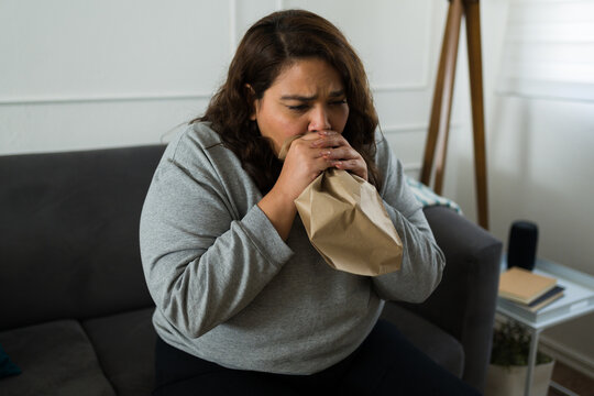 Anxious big woman doing breathing exercises during a panic attack
