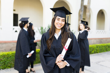 Young woman with her graduation gown at university campus
