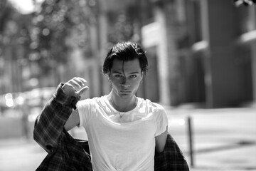 Confident guy posing on town street, looking defiantly at camera