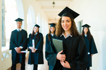 Attractive woman smiling wearing a graduation gown and cap