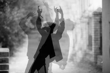 Silhouette of guy dancing on ciity street, multiple exposure