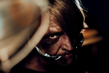 Gagged man face with traces of beatings in dark room