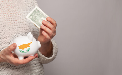 Flag of Cyprus on money bank in Cyprus woman hands. Dotations, pension fund, poverty, wealth,...