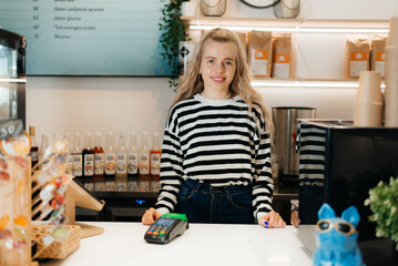 Coffee Business owner Concept - attractive young beautiful caucasian barista in apron smiling at camera in coffee shop counter.