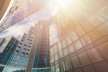 Modern skyscarpers of steel and glass on the background of beautiful cloudy sky, bright sunlight