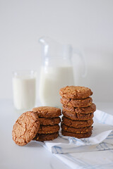 A stack of delicious homemade cookies with a glass of milk on the background