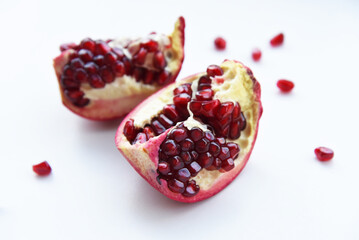Two halves of juicy ripe pomegranate fruit on a white background close-up. Pomegranate Isolated Whole Pomegranate slices Red Healthy on a white background.