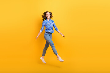 Fototapeta na wymiar Full body photo of cheerful pretty lady jumping have good mood empty space isolated on yellow color background