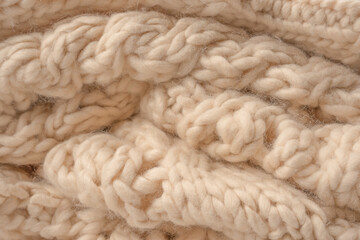 A fragment of beige knitted fabric, knitted from white sheep wool.