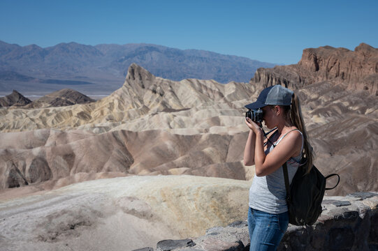 a young girl in profile taking photos of the desert landscape in Dead Valley Desert