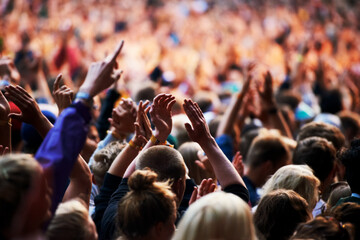 The crowds are enjoying the atmosphere. Shot of a crowd of young people at an outdoor music...