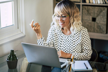 Happy businesswoman enjoy remote working from home distance office on laptop doing video call....
