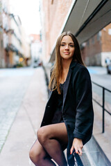 Fototapeta premium Happy Successful Businesswoman Holding a Takeaway Coffee Cup and smartphone on the Street Next to a park