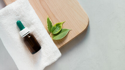 Glass dropper bottle mockup. Body care and spa. Natural cosmetics. skin care bottle. bottle for essential oils and cosmetics lies on a white towel. Dropper. Spa still life with towel, wooden board