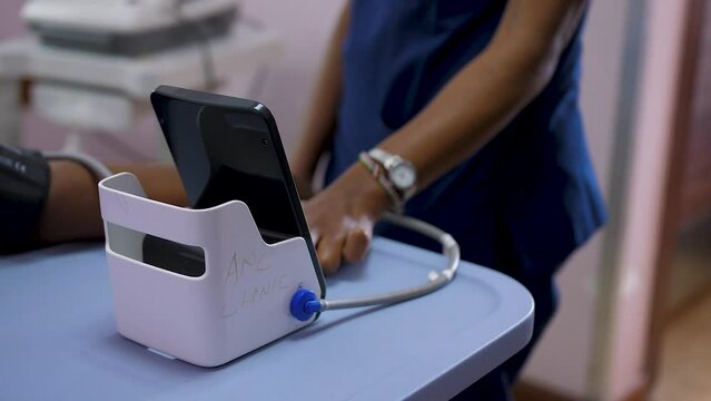 African lady measuring patient blood pressure. African Health care provider measuring patient blood pressure.