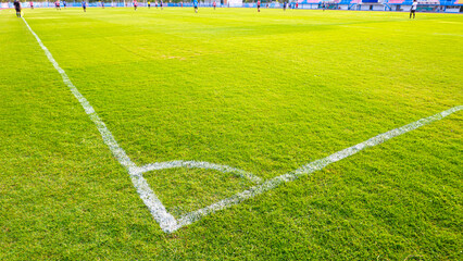 Focus at white corner line on soccer field while the match is in progress, high angle view with...