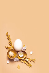 Monochrome flat lay Easter eggs composition decoration with twigs and flowers. Easter still life beige