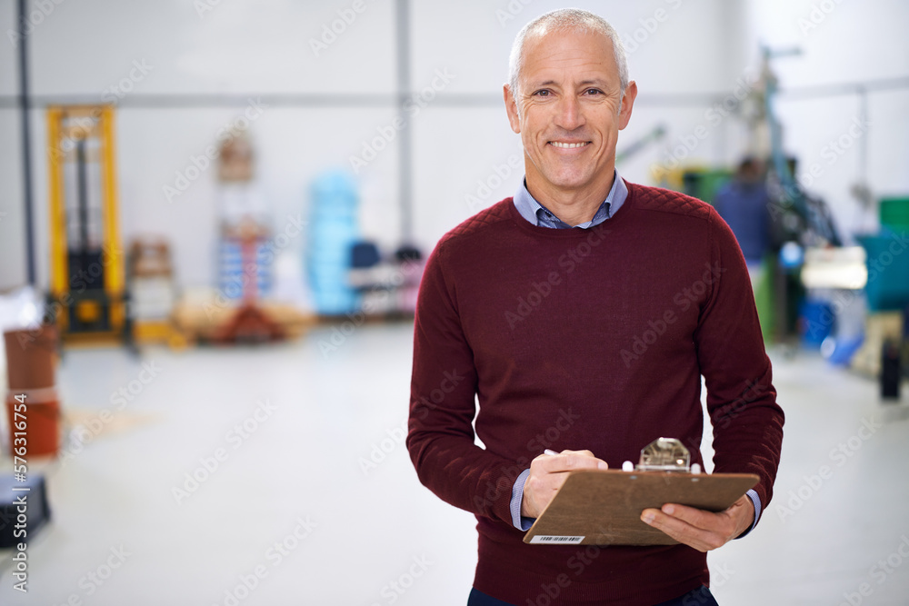 Aufkleber im in charge of this operation. portrait of a factory manager standing with a clipboard.