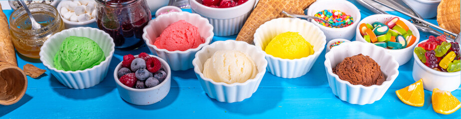 Ice cream festival background, Summer ice cream buffet with various gelato sundaes flavors. sweet toppings and sprinkles, high-colored blue wooden background to view copy space