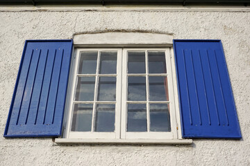 old fashioned window frame with blue shutters. close up of vintage style windows 