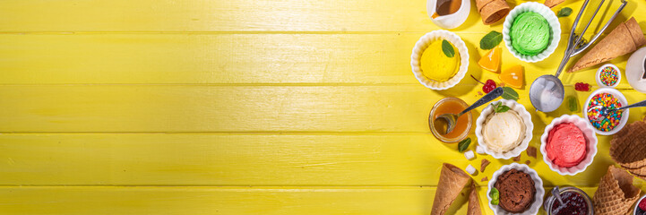 Ice cream festival background, Summer ice cream buffet with various gelato sundaes flavors. sweet toppings and sprinkles, high-colored yellow wooden background to view copy space