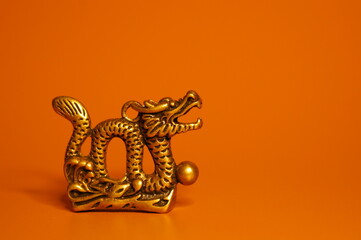 A dragon figurine on a bright colored background. Religious and spiritual symbol.