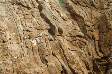 Texture of rough brown rock cliff as natural background