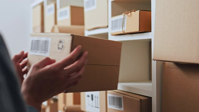 Productivity, An employee of a transport company Concentratedly takes a cardboard box from a rack with his hands, in a warehouse of a transport company. The product packer is in the factory, package
