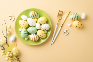 Easter concept. Top view photo of green plate with colorful easter eggs cutlery and easter bouquet on isolated pastel beige background