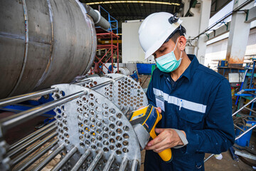 Male worker inspecting surface on heat exchanger, tube bundle industrial construction warehouse...