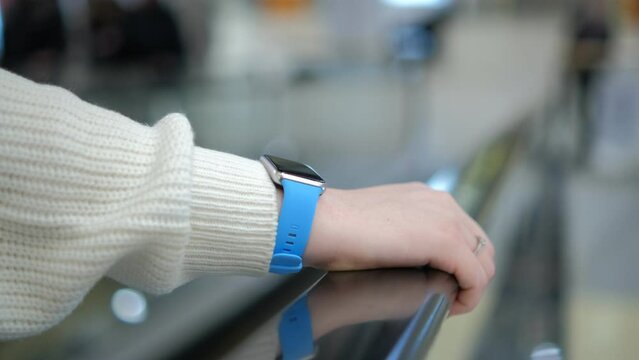 Moll. A young woman in a shopping mall stands on an escalator. 4K