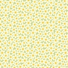 Seamless pattern of abstract yellow narcissus flowers on a green background.
