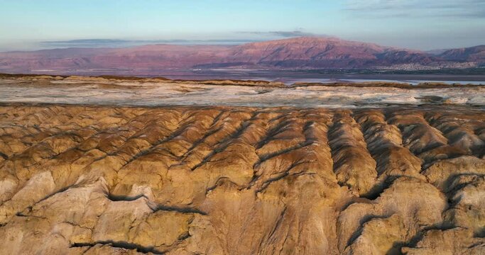 Aerial footage of the Sodom mountains in the southern Dead Sea. In the background the amazing sunset is reflected on the Dead Sea and the Jordan mountains. Filmed in C4K Apple ProRes 422 HQ