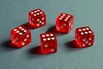 Random number generator. Five red dice with numerical values lie in a chaotic order.