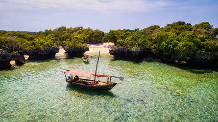 Naklejka na ściany i meble Board a traditional wooden dhow boat and discover the natural wonders of Zanzibar's Blue Safari, from coral reefs to deserted islands.