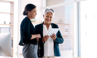 These women are all about making smart moves. Shot of two businesswomen working together on a digital tablet in an office.