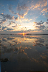 Vertical Image of Sunrise and Beautiful Clouds over a quiet bay.