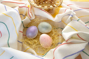 Three painted Easter eggs lie on a striped tablecloth. Religion concept, Easter.
