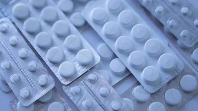 Many different blister packs with tablets lying on table, counterfeit medicines, cheap and unlicensed analogues, criminal case