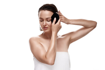 Beauty portrait of an attractive Caucasian woman with dewy skin and wet hair using a gua sha stone, promoting natural skincare and wellness