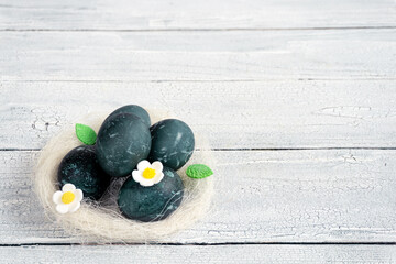 Eggs in a decorative white nest are painted for Easter celebration. Festive decor for breakfast