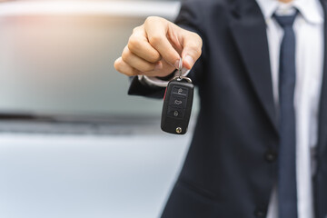 transportation rental automotive business concept. Close up hands of rental auto agent giving car remote key to client